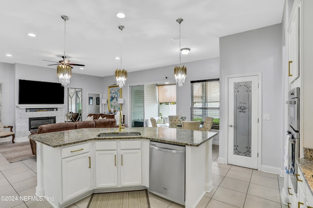 kitchen featuring ceiling fan with notable chandelier, light stone countertops, pendant lighting, appliances with stainless steel finishes, and white cabinetry