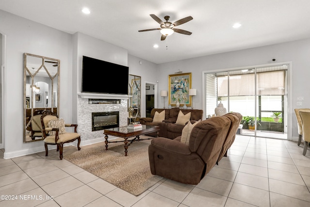 living room featuring ceiling fan, light tile patterned flooring, and a stone fireplace