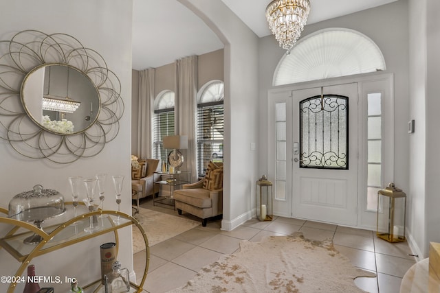 foyer entrance with light tile patterned floors, plenty of natural light, and a notable chandelier