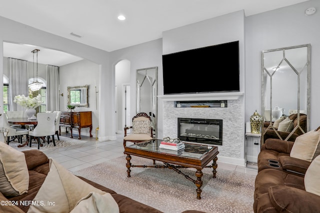 living room with light tile patterned floors and a stone fireplace