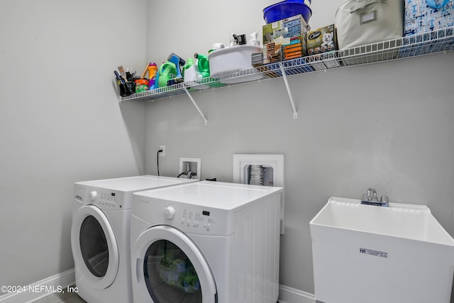 laundry area with washing machine and clothes dryer and sink