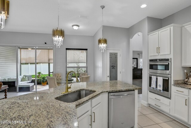 kitchen featuring white cabinets, appliances with stainless steel finishes, sink, and a notable chandelier