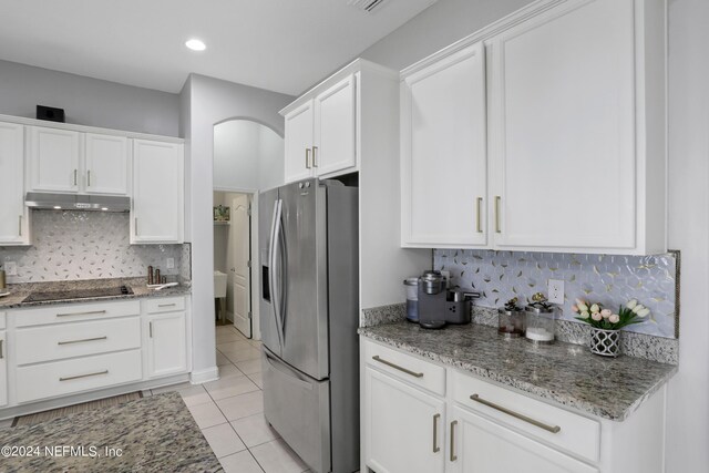 kitchen with white cabinets, stainless steel fridge, and light tile patterned floors