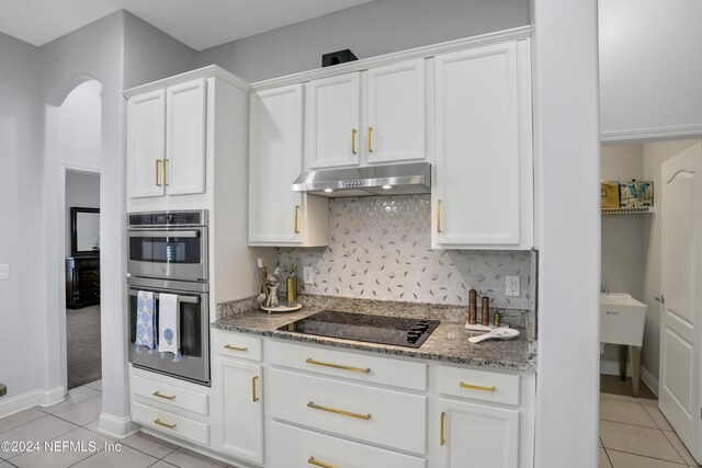 kitchen with black electric cooktop, double oven, and white cabinetry