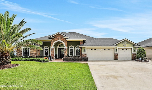 view of front of house with a garage and a front lawn