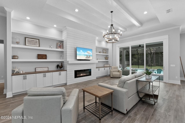 living room featuring an inviting chandelier, ornamental molding, built in features, a fireplace, and beam ceiling