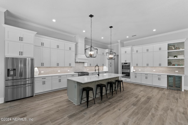 kitchen featuring a kitchen breakfast bar, white cabinetry, custom range hood, and stainless steel appliances