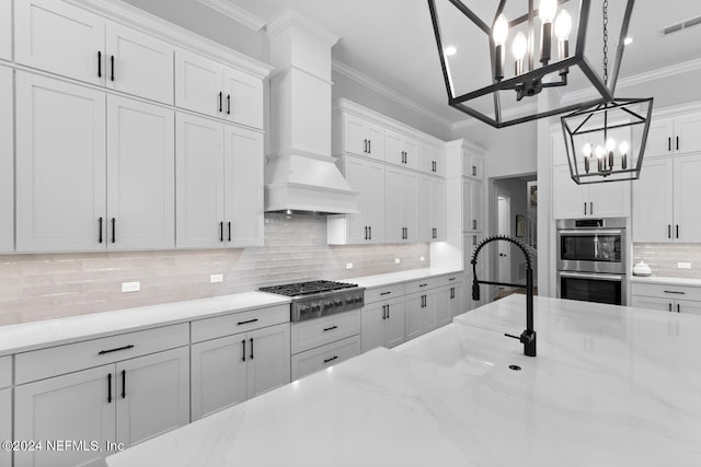 kitchen with white cabinetry, sink, stainless steel appliances, and ornamental molding