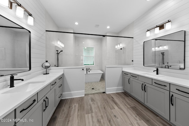 bathroom featuring separate shower and tub, vanity, and tile walls