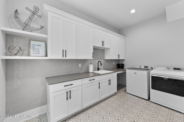 washroom with separate washer and dryer, sink, light tile patterned floors, and cabinets