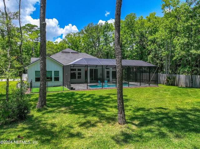 back of property with a yard, a fenced in pool, and a lanai