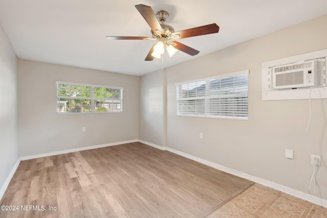 unfurnished room featuring ceiling fan, a healthy amount of sunlight, a wall mounted air conditioner, and light hardwood / wood-style floors