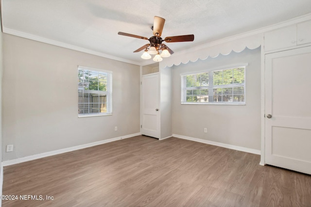 unfurnished bedroom with ceiling fan, light wood-type flooring, a textured ceiling, and ornamental molding