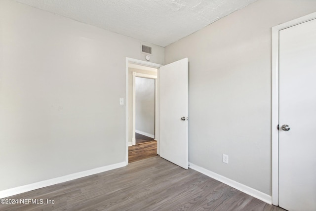 unfurnished bedroom with hardwood / wood-style floors and a textured ceiling