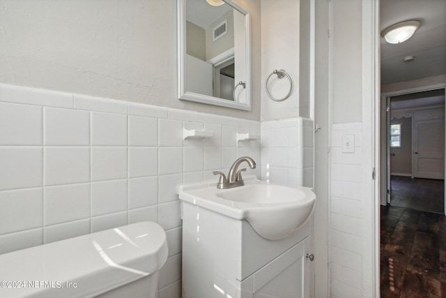 bathroom featuring vanity and tile walls