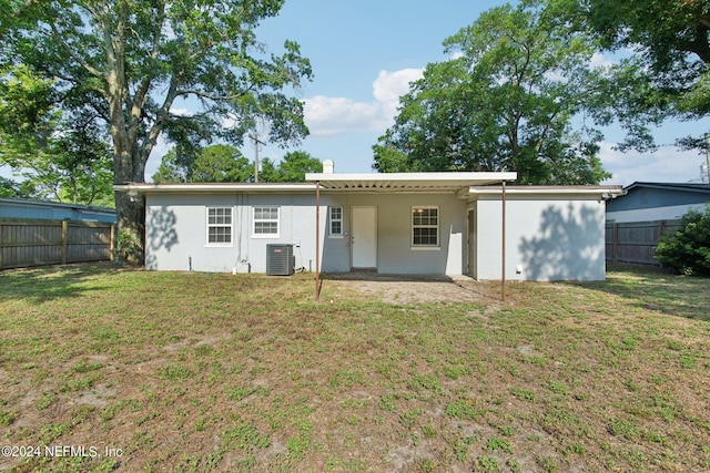 rear view of house featuring a yard and cooling unit