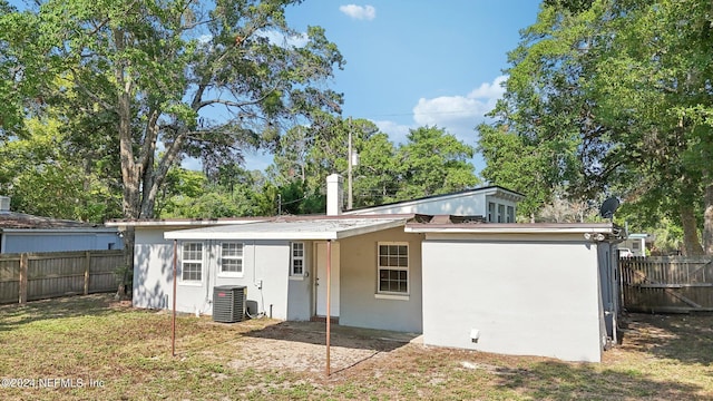 rear view of house featuring a yard and central AC