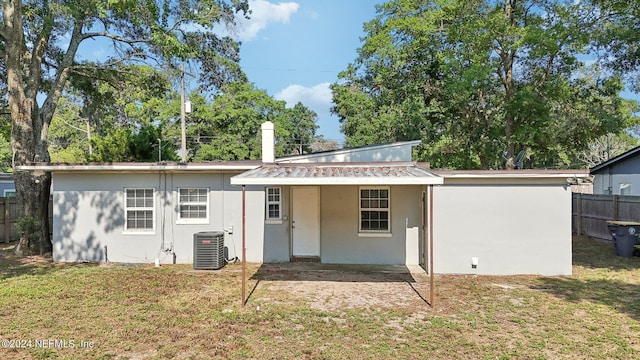 rear view of property with a lawn and central AC