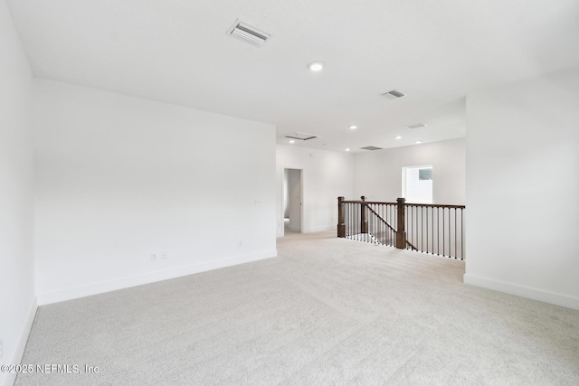 empty room featuring recessed lighting, baseboards, visible vents, and light colored carpet