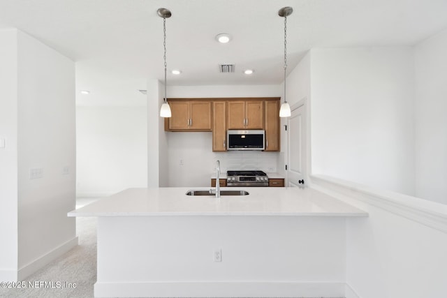 kitchen featuring pendant lighting, stainless steel appliances, and a sink