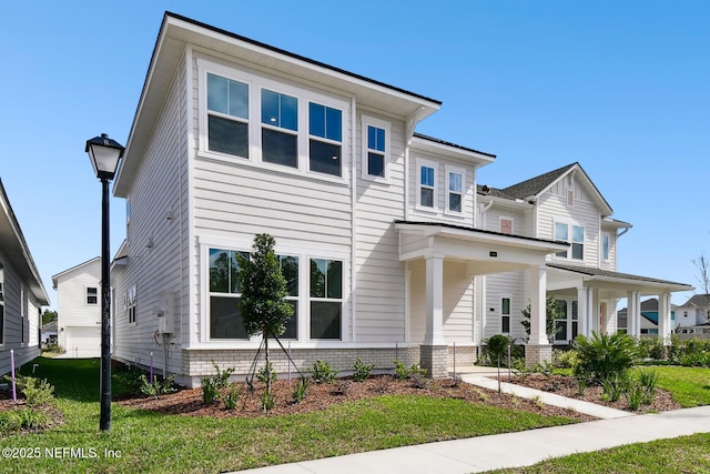 view of front of house with a porch, a front lawn, and brick siding