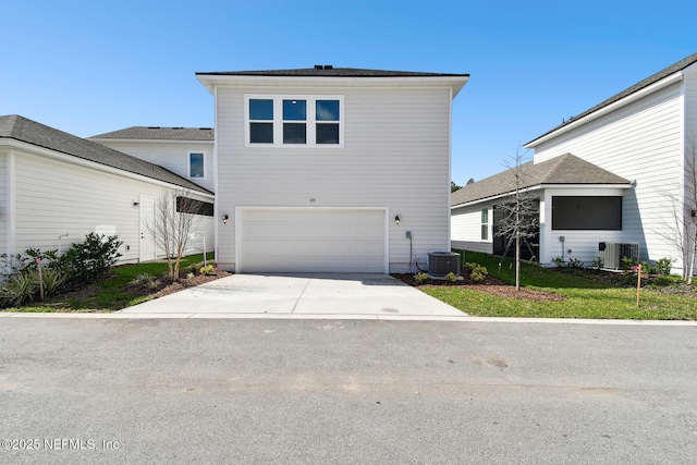 traditional home with central air condition unit, driveway, a garage, and a front yard