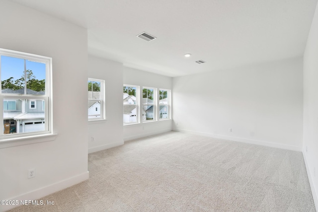 spare room with light colored carpet, visible vents, baseboards, and recessed lighting