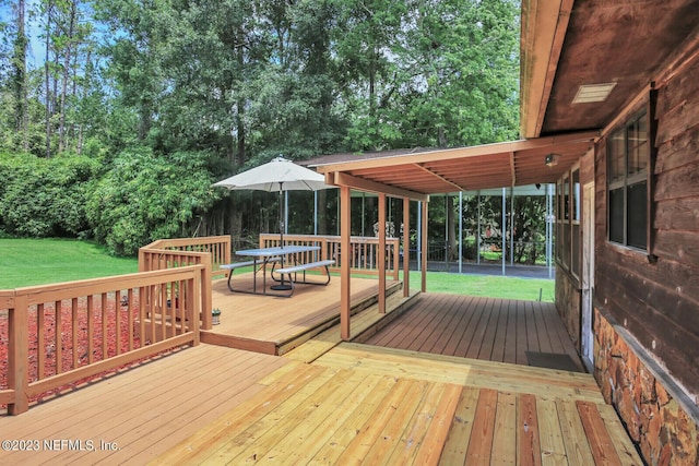 wooden deck with a yard and outdoor dining space