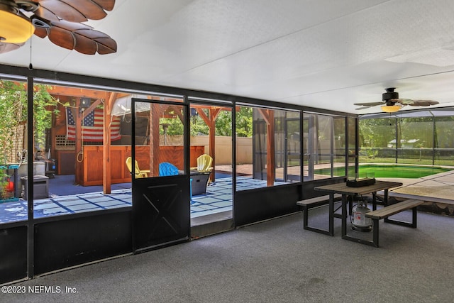unfurnished sunroom featuring ceiling fan