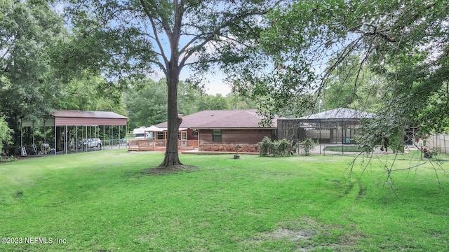 view of yard with fence, a deck, and a carport