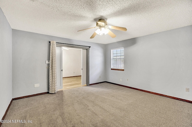 spare room featuring a ceiling fan, carpet flooring, a textured ceiling, and baseboards