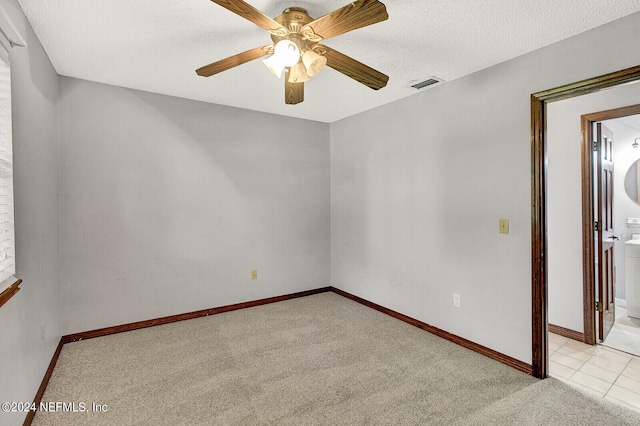 carpeted empty room featuring visible vents, ceiling fan, a textured ceiling, and baseboards