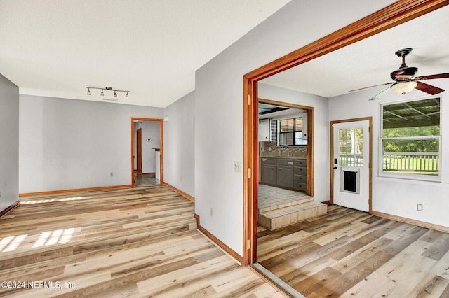 spare room featuring ceiling fan, baseboards, and wood finished floors