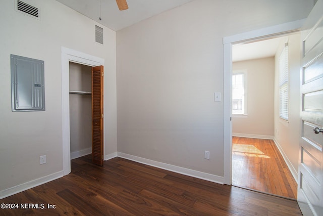 unfurnished bedroom with visible vents, hardwood / wood-style flooring, electric panel, and baseboards