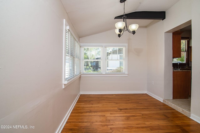 unfurnished dining area with lofted ceiling, wood finished floors, and baseboards