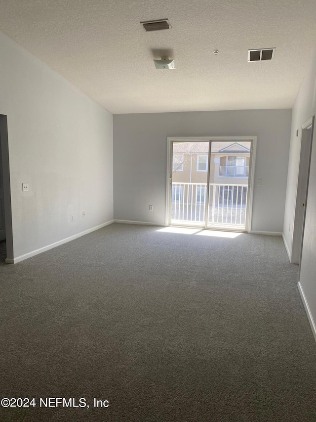 carpeted spare room with a textured ceiling