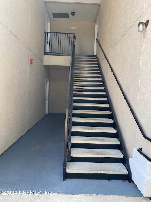 stairs featuring concrete flooring