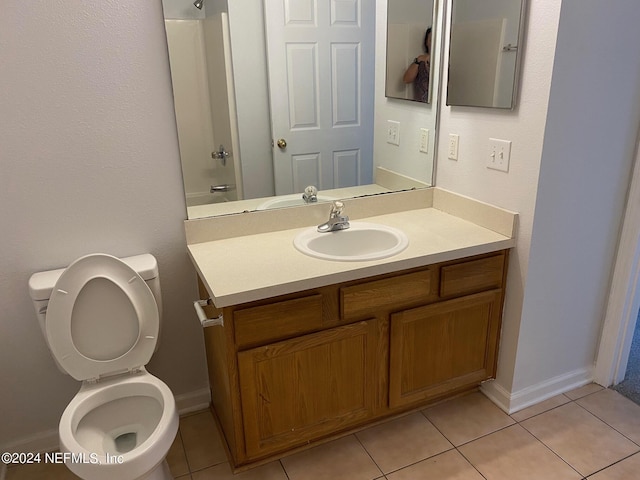 bathroom with tile patterned flooring, vanity, toilet, and walk in shower