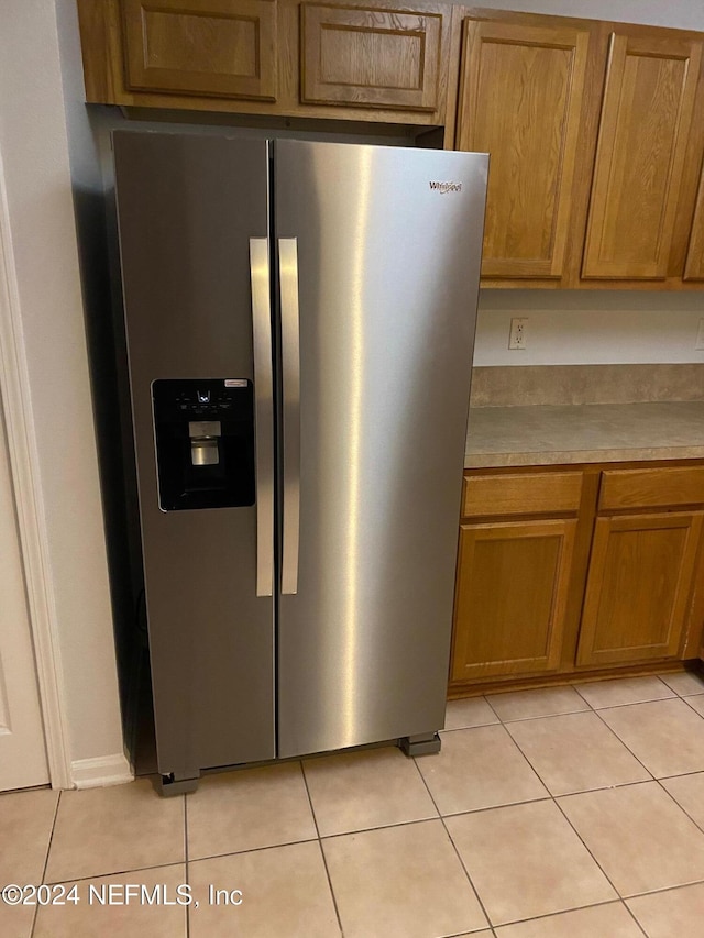 kitchen featuring stainless steel refrigerator with ice dispenser and light tile patterned floors