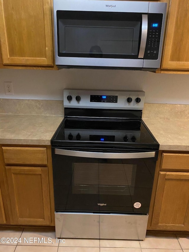 kitchen featuring light tile patterned floors and stainless steel appliances