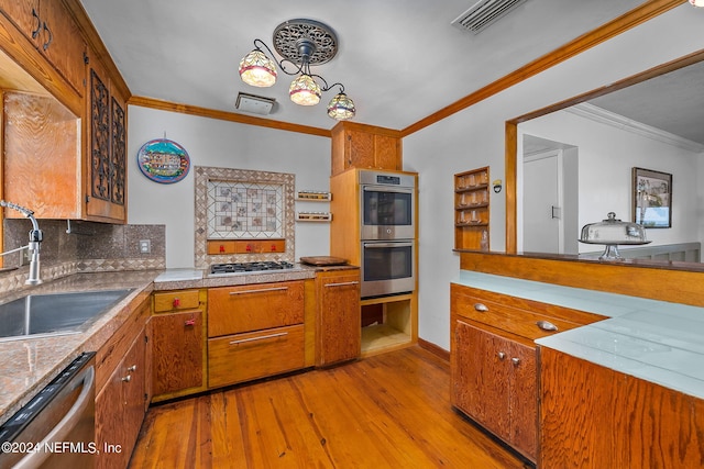 kitchen featuring light hardwood / wood-style flooring, tasteful backsplash, stainless steel appliances, sink, and ornamental molding