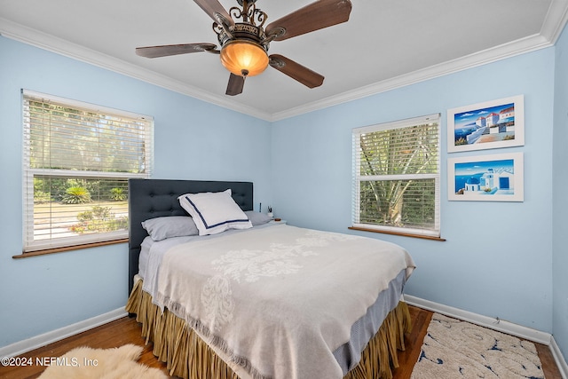 bedroom with hardwood / wood-style floors, crown molding, and multiple windows