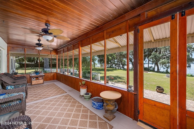 sunroom / solarium featuring a healthy amount of sunlight, wooden ceiling, and ceiling fan