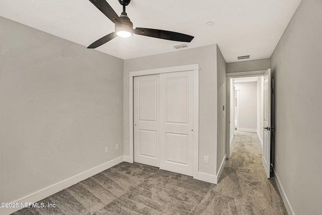 unfurnished bedroom featuring carpet flooring, ceiling fan, and a closet