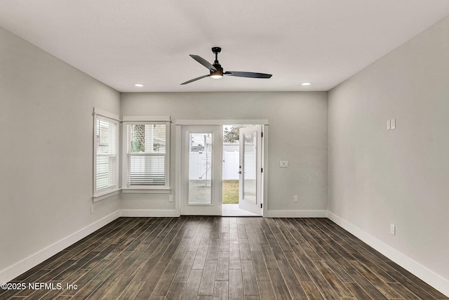 spare room with dark hardwood / wood-style flooring and ceiling fan