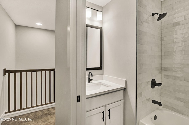 bathroom with tiled shower / bath and vanity