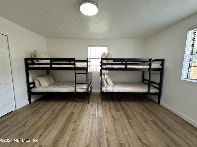 bedroom featuring hardwood / wood-style flooring and a textured ceiling