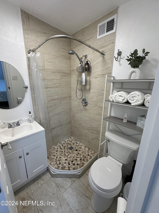 bathroom featuring vanity, a shower with curtain, a textured ceiling, and toilet