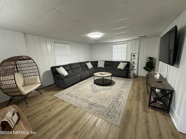 living room featuring light hardwood / wood-style flooring and a paneled ceiling