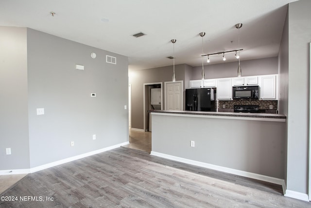 kitchen with tasteful backsplash, track lighting, black appliances, pendant lighting, and white cabinets